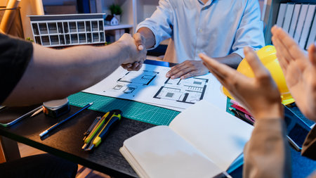 Engineers and architects analyze construction models and discuss project strategies, combining...