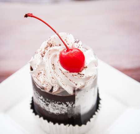 a piece of cherry cup cake in white dish