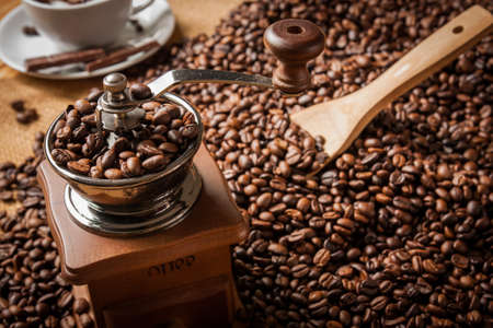 coffee grinder and beans background on sack and cup of coffeeの写真素材