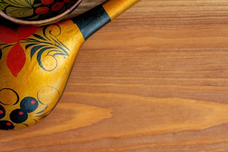 Russian wooden spoon on brown background. National musical instrument. Painted in the traditional Khokhloma style. There's room for your text.の写真素材
