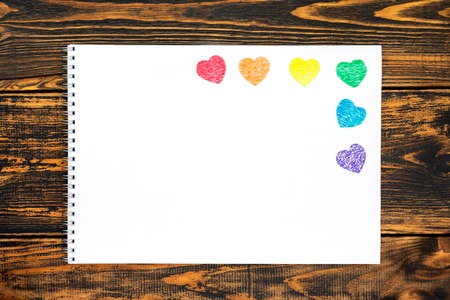 White card with colored hearts cut from paper. Hearts located on right and painted in the colors of...