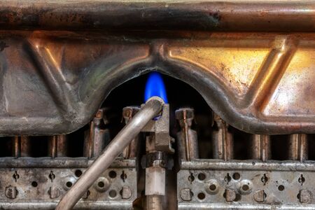 old worn copper gas boiler without protective casing. is in standby mode. close up photos. the concept of carbon monoxide leakage and poisoning. safety of exploitation.の写真素材
