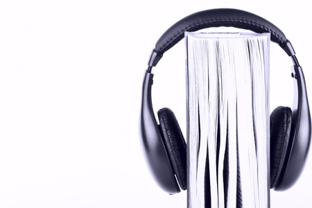 Book with headphones on the white background in blue key