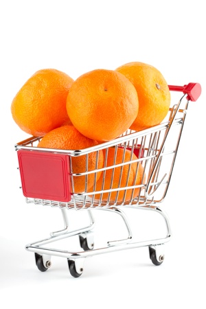 Buying healthy food. Shopping trolley with orange on whiteの写真素材