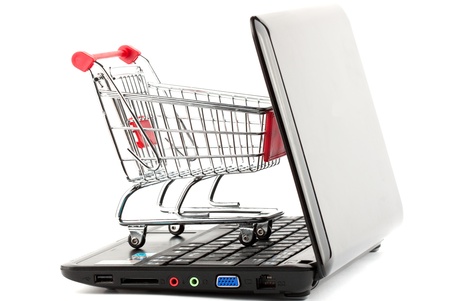 Online shopping. Shopping cart with notebook on the white.の写真素材