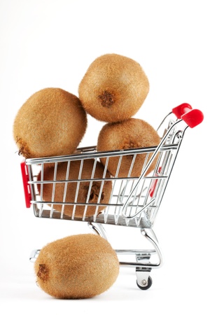 Buying healthy food. Shopping trolley with kiwi on whiteの写真素材