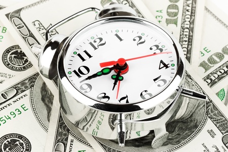 Time and money concept image. Alarm clock and US currency
