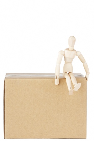 Wooden mannequin sitting on top the box on the white backgroundの写真素材