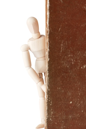 Wooden dummy and old book on a white backgroundの写真素材