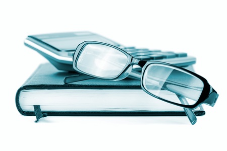 Business concept with diary, glasses and calculator on a white background in blue keyの写真素材