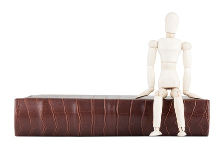 Wooden dummy and old book on a white backgroundの写真素材