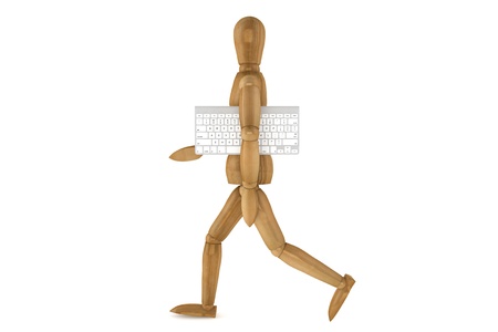 Wooden dummy with computer keyboard on a white backgroundの写真素材