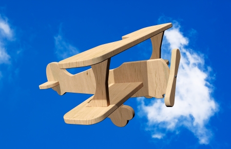 3d Wooden toy airplane on a blue skyの写真素材
