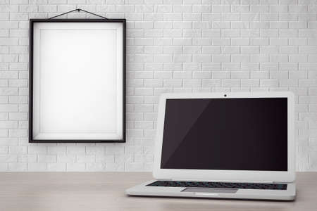 Modern Laptop in front of Brick Wall with Blank Frame extreme closeup