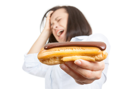 Health Food Concept. Beautiful Pretty Young Woman Refusing to Eat Chocolate Eclair on a white...