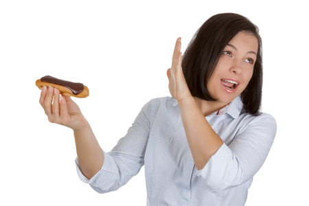 Health Food Concept. Beautiful Pretty Young Woman Refusing to Eat Chocolate Eclair on a white...
