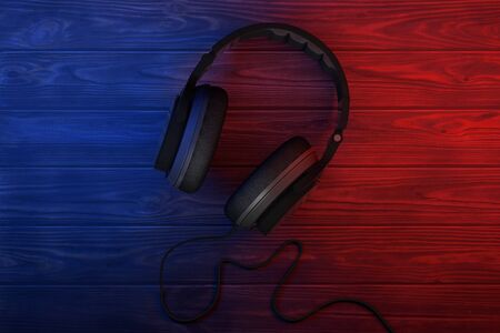 Black Headphones in Color Lights on a wooden table. 3d Renderingの写真素材