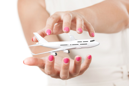 Two Woman Hands Protecting White Jet Passenger's Ð¡ommercial Airplane on a white background. 3d Renderingの写真素材