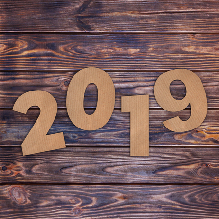 Cardstock Numbers 2019 Happy New Year Sign over wooden table background. 3d Renderingの写真素材