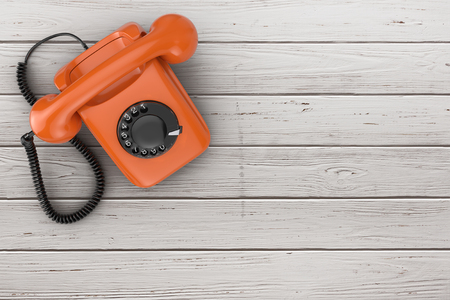 Top View of Orange Vintage Styled Rotary Phone on a plank wooden table background 3d Renderingの写真素材