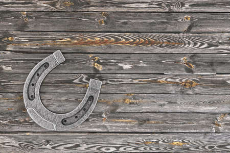 Old Steel Lucky Horseshoe on a wooden plank background. 3d Renderingの写真素材