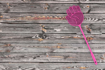 Pink Flyswatter in Shape of Hand on a plank wooden table background. 3d Renderingの写真素材