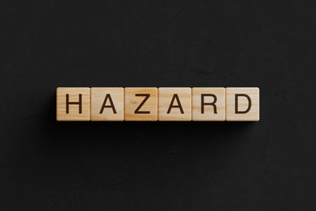 Row of Wooden Cubes Blocks with Hazard Sign on a black background. 3d renderingの写真素材