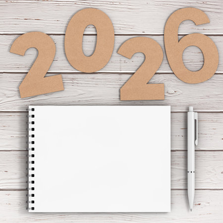 Cardstock Numbers 2026 Happy New Year Sign near White Spiral Paper Cover Notebook with Pen over...