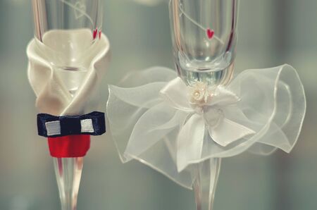 Two wedding glasses decorated in the style of the bride and groom.の写真素材