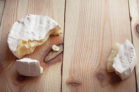 Sliced round camembert cheese on a wooden planksの写真素材