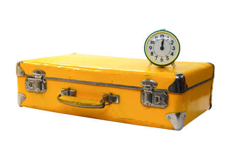 old yellow suitcase with green alarm clock on a whiteの写真素材