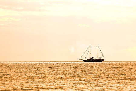 Boat silhouette at sunset in seaの写真素材