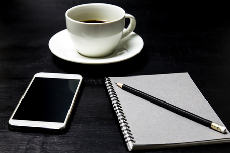 Coffee with notebook ,pencil and mobile phone on wood background.の写真素材