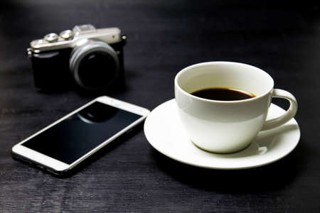 Coffee with camera and mobile phone on wood background.の写真素材