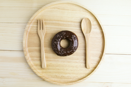 Chocolate Donuts on wooden plate on wooden backgroundの写真素材