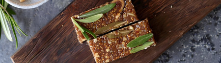 Closeup of homemade raw fig and walnut bars a healthy and nourishing plant based snack on a rustic wooden background  The image showcases the natural ingredients textureの素材