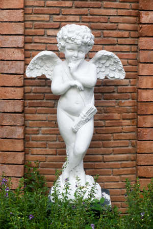 Cupid statue on the brick backgroundの写真素材