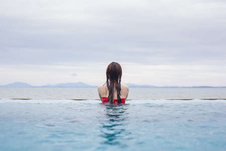 Young woman in bikini by the swimming poolの写真素材