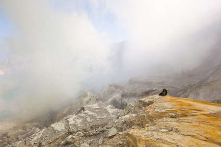 Couple sit to see smoke on the mountainの写真素材