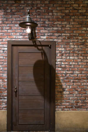 Wooden door on brick wall as texture backgroundの写真素材