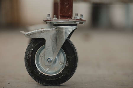 Wheel of scaffolding with shadow on concrete ground in site