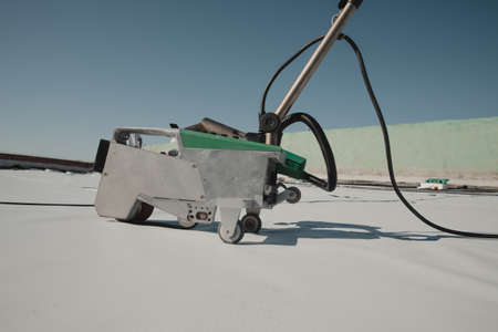Automatic welder hot-air tools welds synthetic membranes on roof.の写真素材