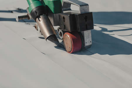 Automatic welder hot-air tools welds synthetic membranes on roof.の写真素材