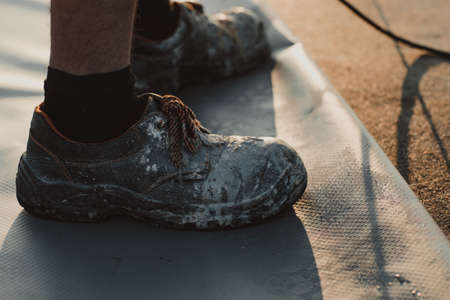 Worker with very worn construction boots.の写真素材