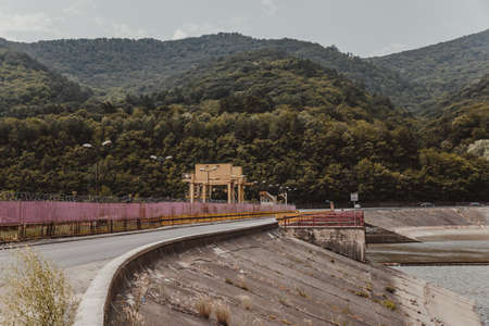 Dam located on the river and a road bridge.High mountains between which a river flows