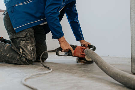 Construction worker using machine polishing surface floor smoothing and finishing hardener or epoxy concrete in the factory.の写真素材