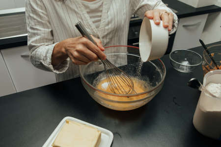 Young woman mix ingredients for making cake in kitchen.の写真素材