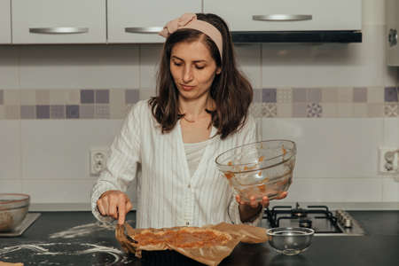Woman puts grated apples for pie.