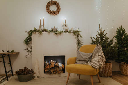 Design room with Christmas tree, fireplace. Interior eco style. Christmas decorated interior of couch and Christmas tree, modern and cozy. happy new year and merry christmasの写真素材