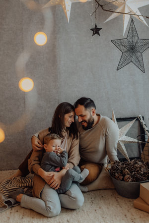 Young family with a cute boy spend intimate moments in the holiday decor at home.の写真素材